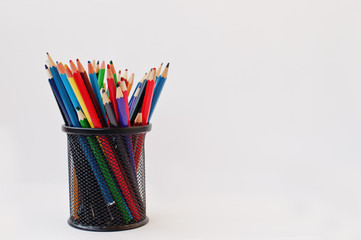Colored pencils in black pencil case  isolated on white background. - obrazy, fototapety, plakaty