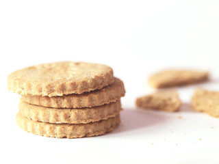 Pile of cookies or biscuits and crumbs on white background