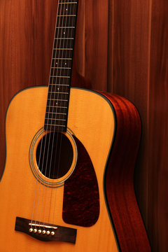 Acoustic guitar on a wooden background.