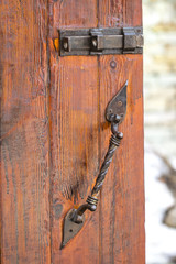 old wooden door with a handle in the background