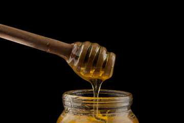 honey wooden spoon isolated on a black background