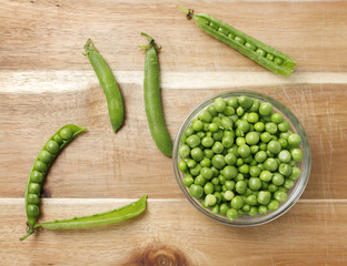 Raw Peas in Glass Bowl, on Wooden Background, Top View