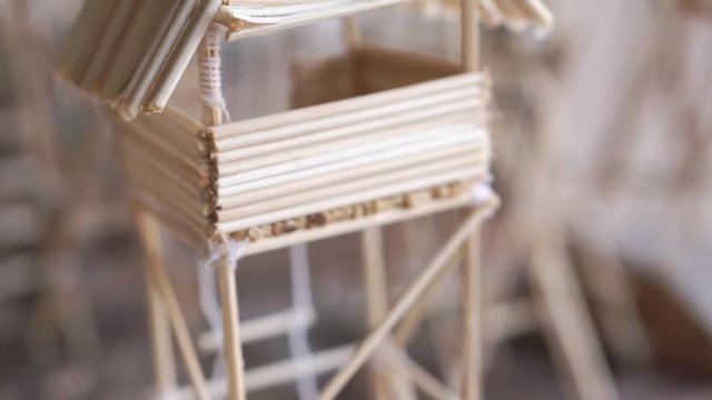 A small construction made from wood stick, glue and thread