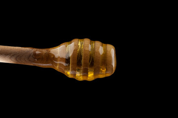 honey wooden spoon isolated on a black background