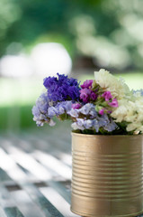 violet flower in golden can as wedding decoration on sunny day