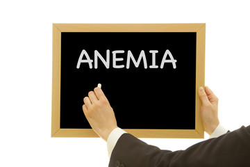 Woman hand writing ANEMIA on chalkboard isolated on white background.