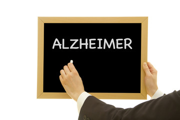 Woman hand writing ALZHEIMER on chalkboard isolated on white background.