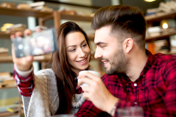 Self portrait making at restaurant couple enjoying together. Photo mobile posing for social networks.