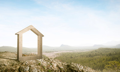 Conceptual image of concrete home sign on hill and natural lands