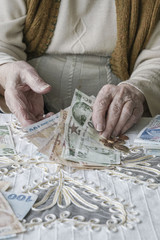Wrinkled hands counting Turkish Lira banknotes