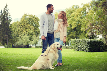 happy couple with labrador dog walking in city