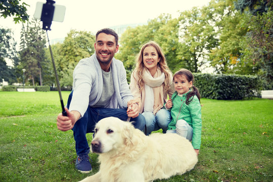 happy family with dog taking selfie by smartphone