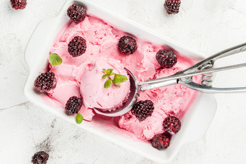 Homemade berry ice cream to the pan (bowl), with blackberries and mint leaves. On the white stone table, top view copy space
