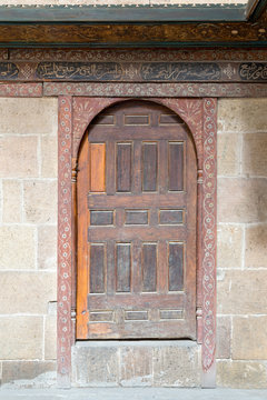Wooden aged vaulted door and stone wall, Medieval Cairo, Egypt