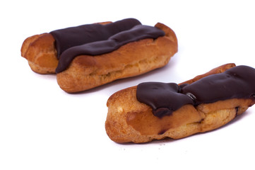 Sweet three chocolate eclairs isolated on white. Traditional french cakes cooked from choux dough...
