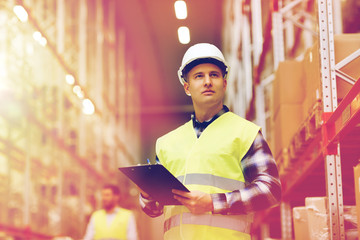 man with clipboard in safety vest at warehouse