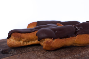 Sweet three chocolate eclairs isolated on white. Traditional french cakes cooked from choux dough...