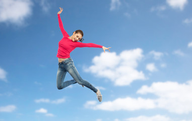 happy young woman jumping in air or dancing