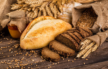 Assortment of baked bread on wooden table background