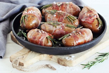 Potato roasted with bacon and rosemary in the cast iron pan.Grill party oder summer dinner ideas.Selective focus.