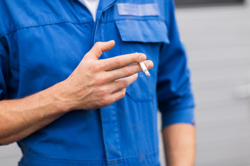 close up of auto mechanic smoking cigarette