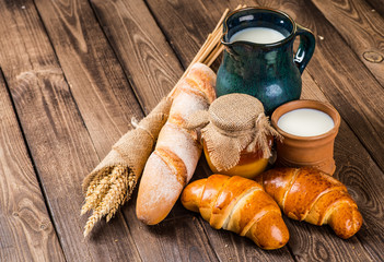 Tasty croissants with spikelets on grey wooden background