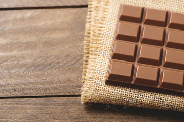 Chocolate tablet on brown fabric. Horizontal shoot.