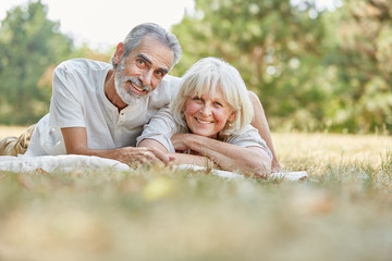 Senioren Paar liegt glücklich im Gras