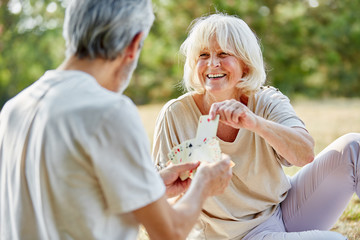 Paar Senioren spielt fröhlich Karten