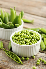 Green peas on a grey wooden table