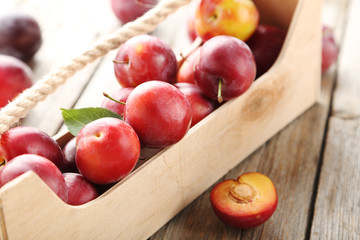 Fresh plums on a grey wooden table