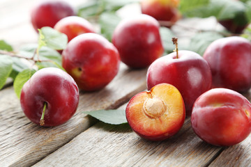 Fresh plums on a grey wooden table