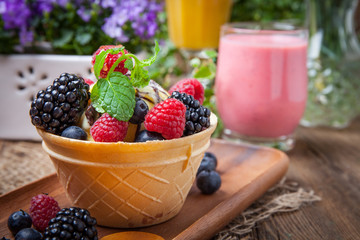 Tasty ice cream dessert with fruit in a waffle bowl.
