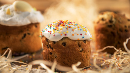 Easter is on a wooden table covered with white icing and sprinkle with colored skittles
