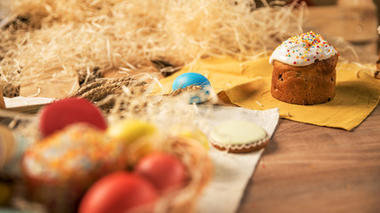 Little Easter is on a festive scarf. Multi-colored Easter eggs lie in a basket with decoration gingerbread