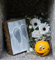 dekoration in einer urnennische auf einem friedhof
