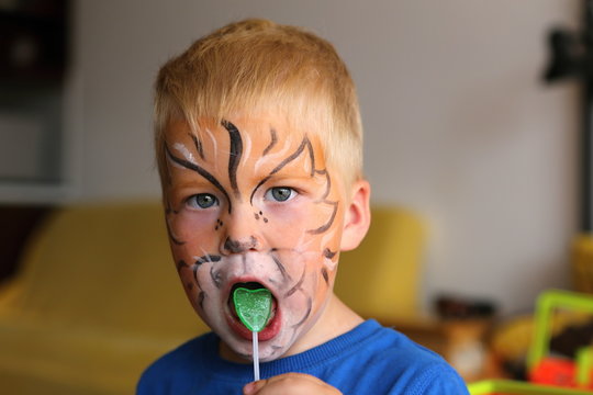 Boy with orange butterfly painted on the face