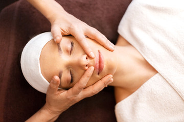Fototapeta na wymiar woman having face and head massage at spa
