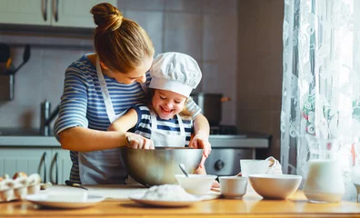 Crédence de cuisine en verre imprimé Cuisinier famille heureuse dans la cuisine. mère et enfant préparant la pâte, cuisent des biscuits