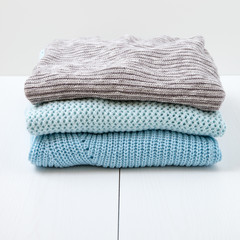 Stack of women's  knit cardigans and sweaters.