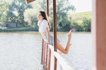 Beautiful girl in the gazebo on the lake