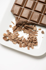 Chocolate tablet on white tray. Isolated. Vertical shoot.