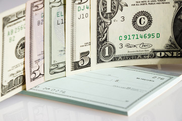 US dollars on checkbook, banknotes as a symbol of cashing the check