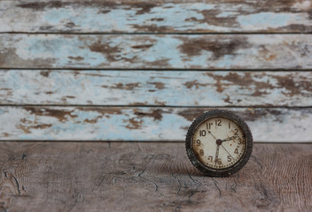 vintage rusty alarm clock on old wooden background