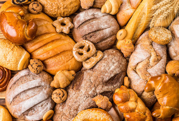 Many mixed breads and rolls shot from above.