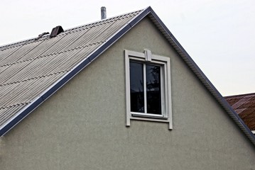 Фасад здания с окном и шиферной крышей