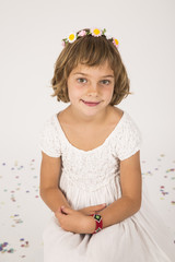 little girl portrait. indoors, confetti on the floor. white  background