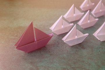 Origami paper big sailboat with small sailboats, female woman leadership, marketing concept, social media influencers, HR recruiter, standing out concept