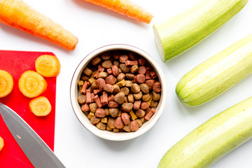 Dogfood set with cut vegetables and knife on table background top view