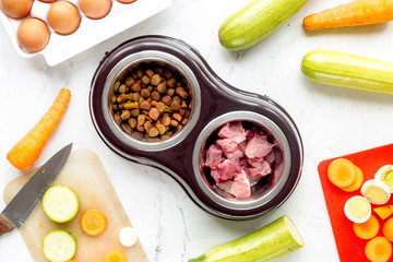 Dogfood set with cut vegetables and knife on table background top view